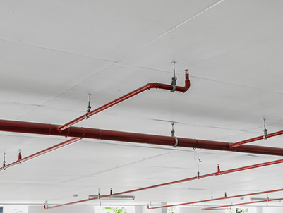 Fire sprinkler and red pipe on white ceiling background