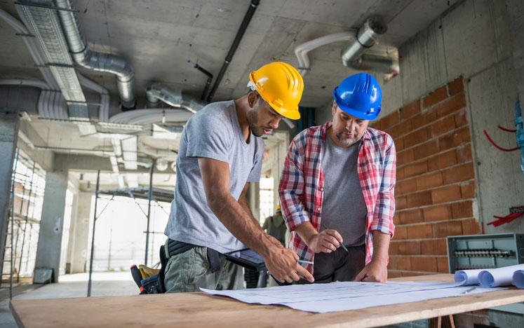 Two Construction Workers Looking Blueprint Together