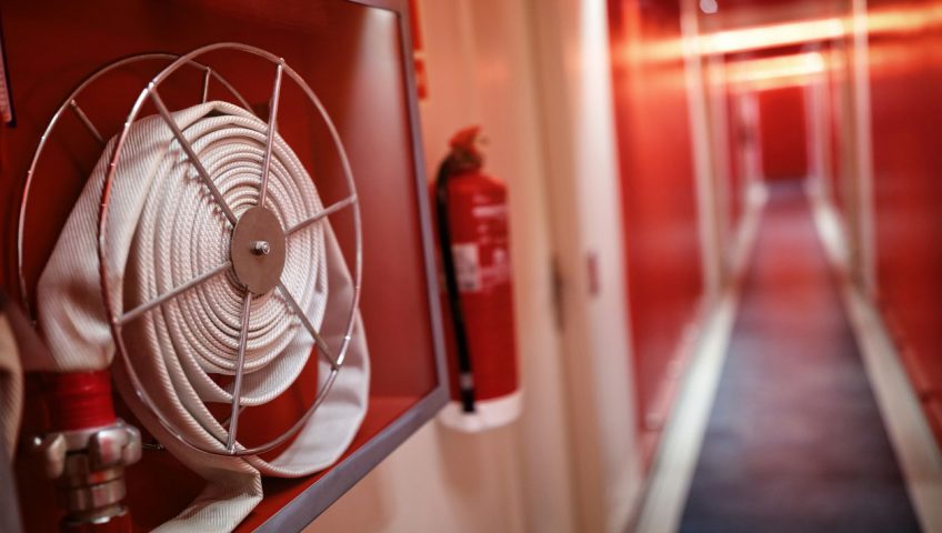 Fire extinguisher and hose reel in hotel corridor